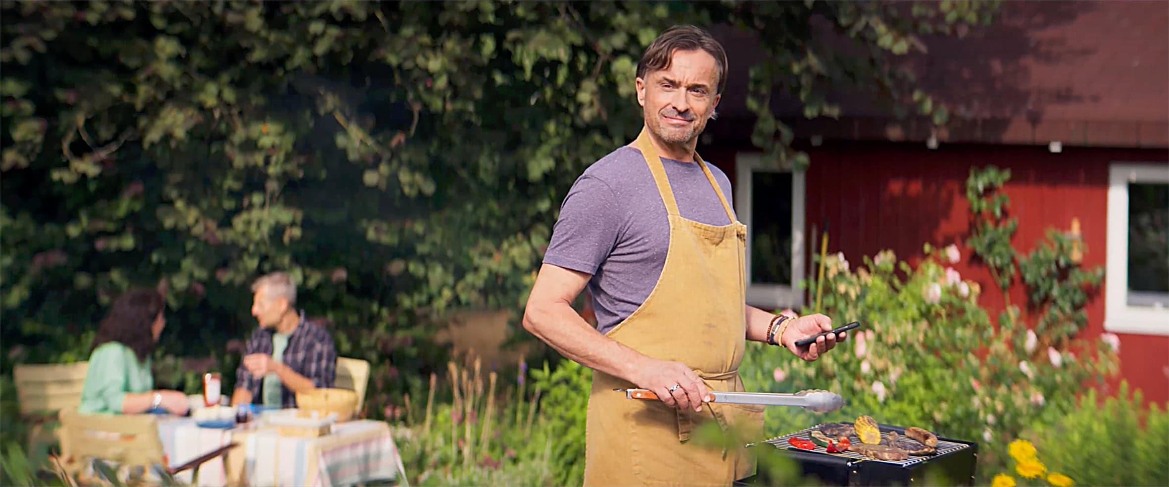 mann mit hörgerät grillt im garten